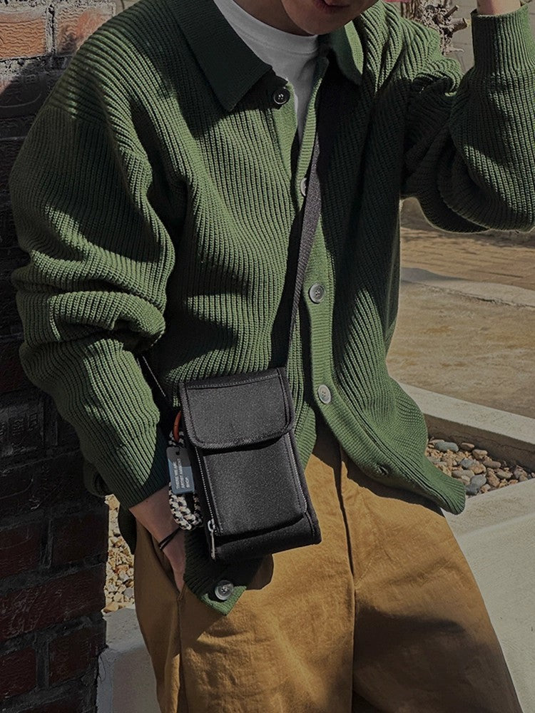 Close-up of the pointed collar and button fastening on a men's cardigan