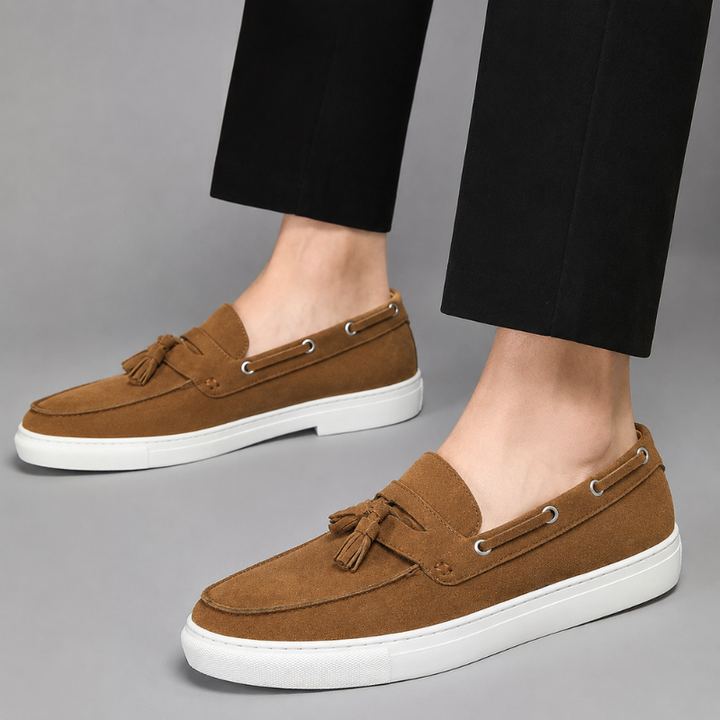 Men's suede tassel loafers angled three-quarter view with classic moccasin stitching