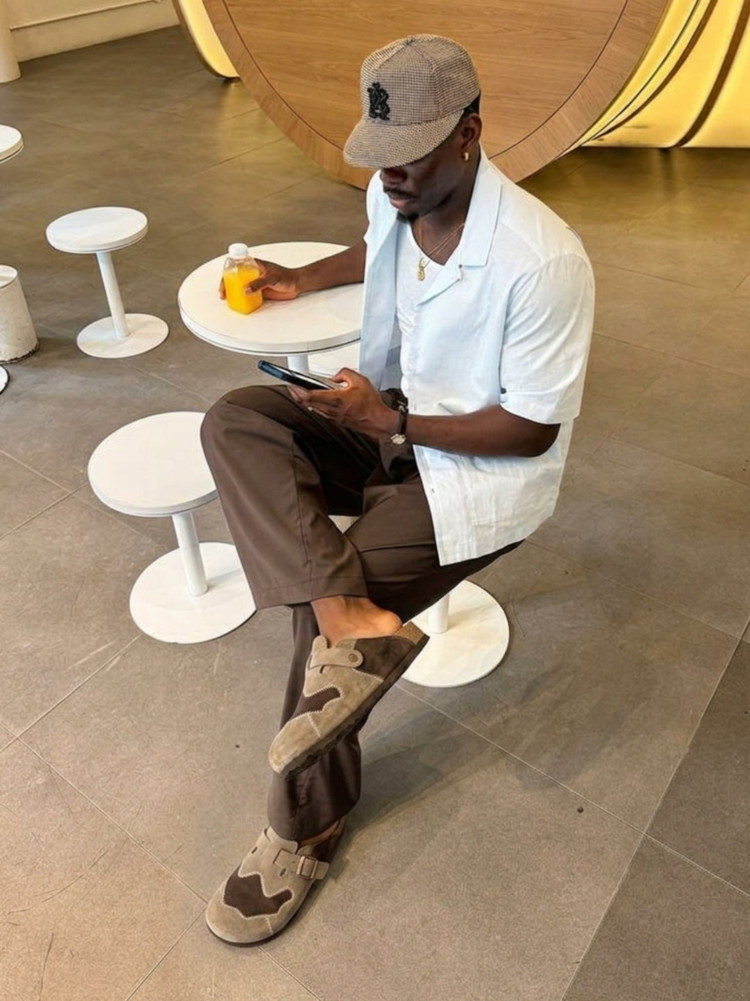 Pair of men's beige suede clogs displayed from the side