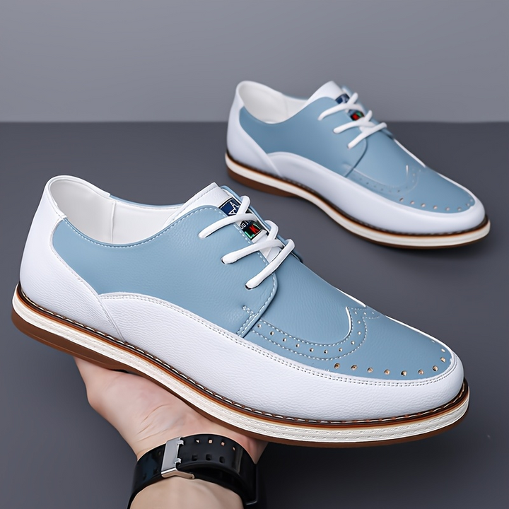 Three-quarter view of men's brogue leather shoes in a classic two-tone finish