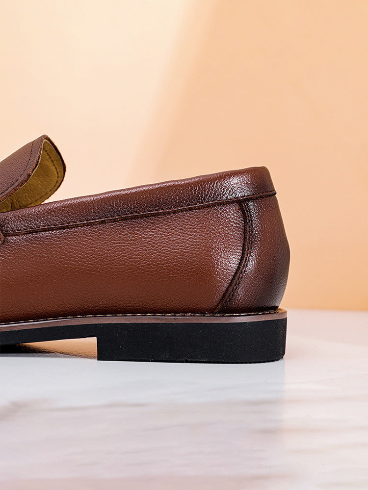 Close-up of the front detailing on men's leather slip-on penny loafers