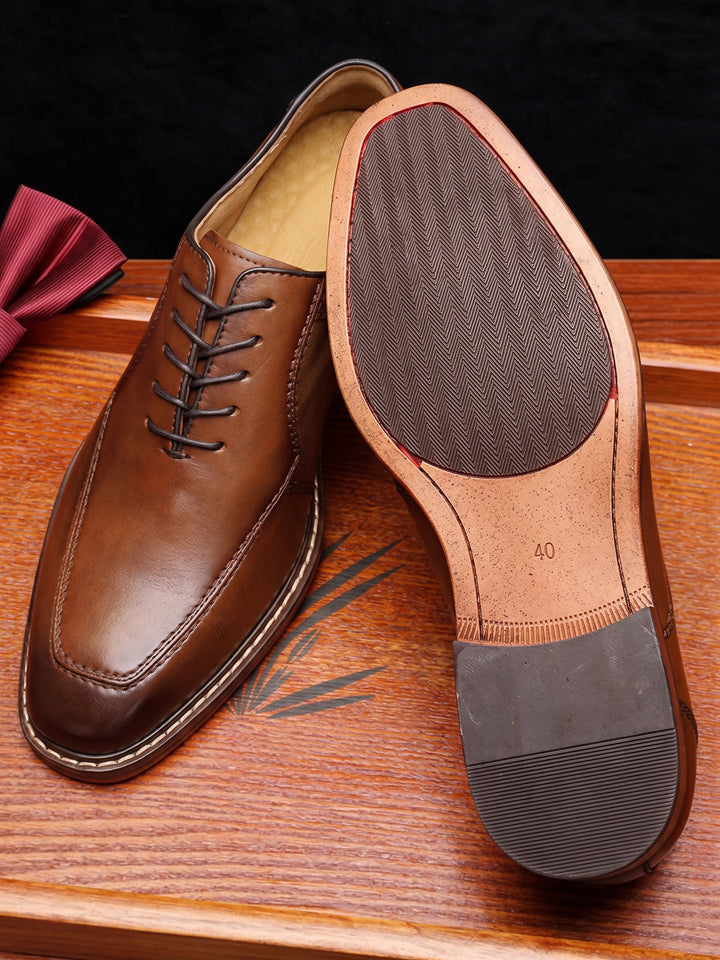 Top view of polished men's derby shoes showing rounded toe and lace detail