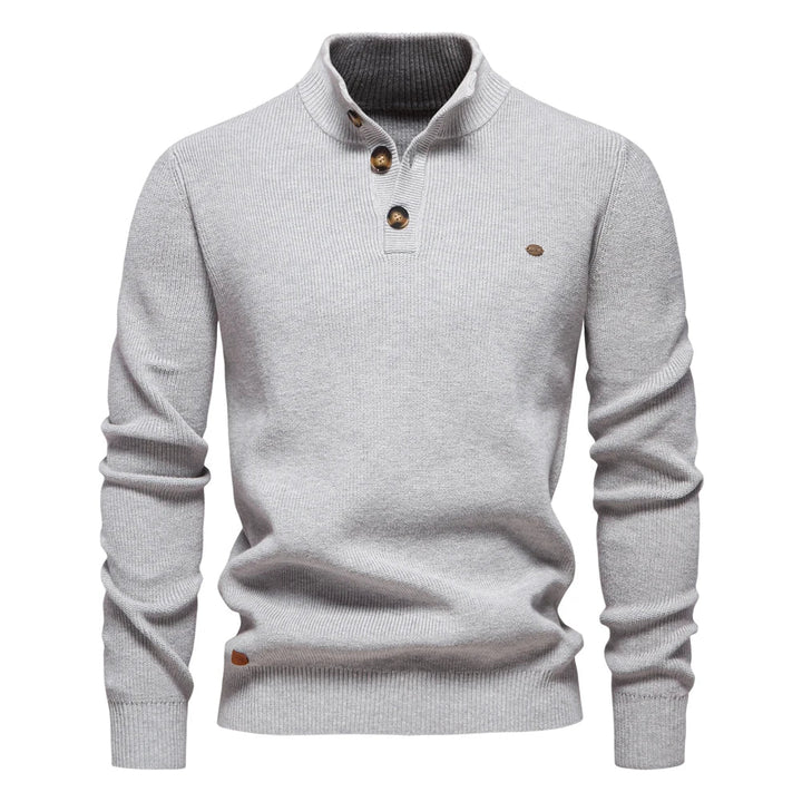 Detail of the neckline and button fastening on the jumper