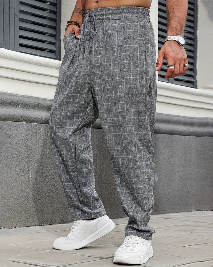Full-length view of men's checked drawstring trousers in a relaxed fit