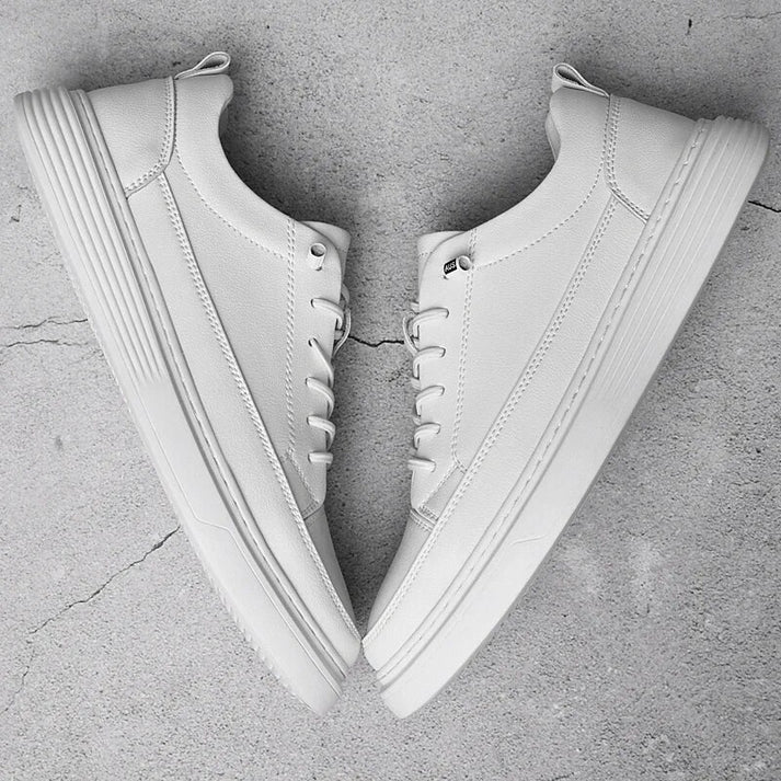 Pair of men's white leather low-top trainers on a white background