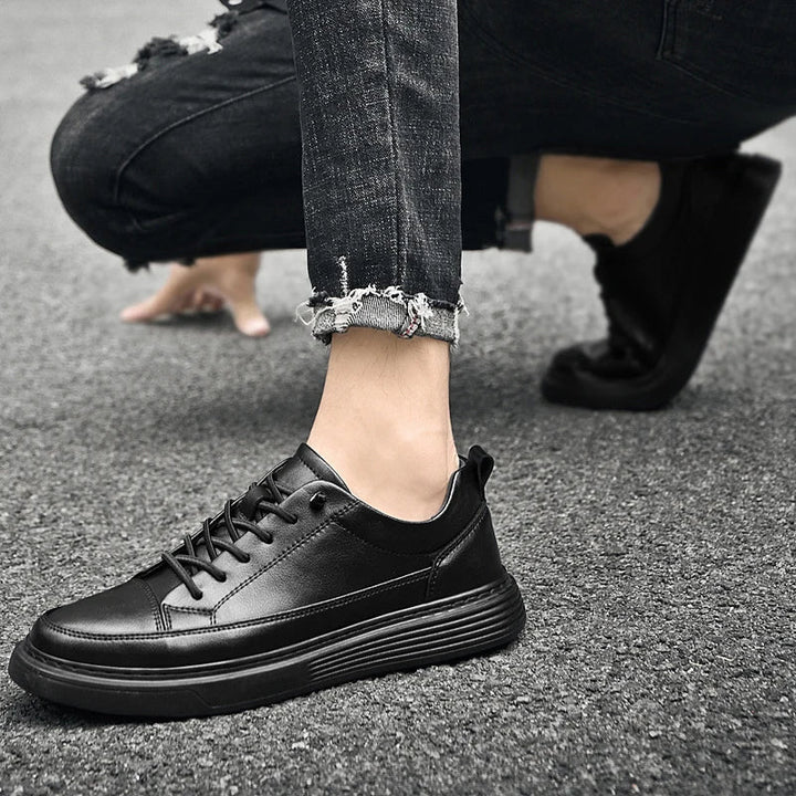 Three-quarter view of men's white low-top trainers in leather