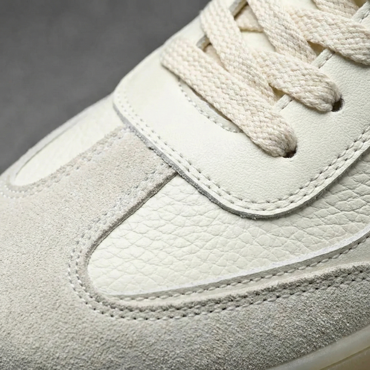 Men's casual low top lace-up faux leather trainers shown from an angled view