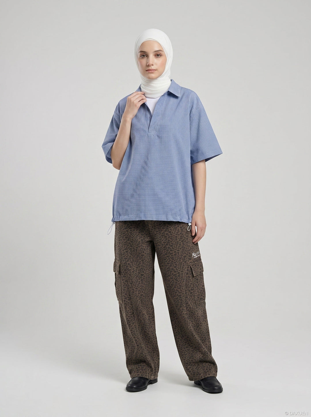 Model wearing men's blue and white gingham shirt side pose