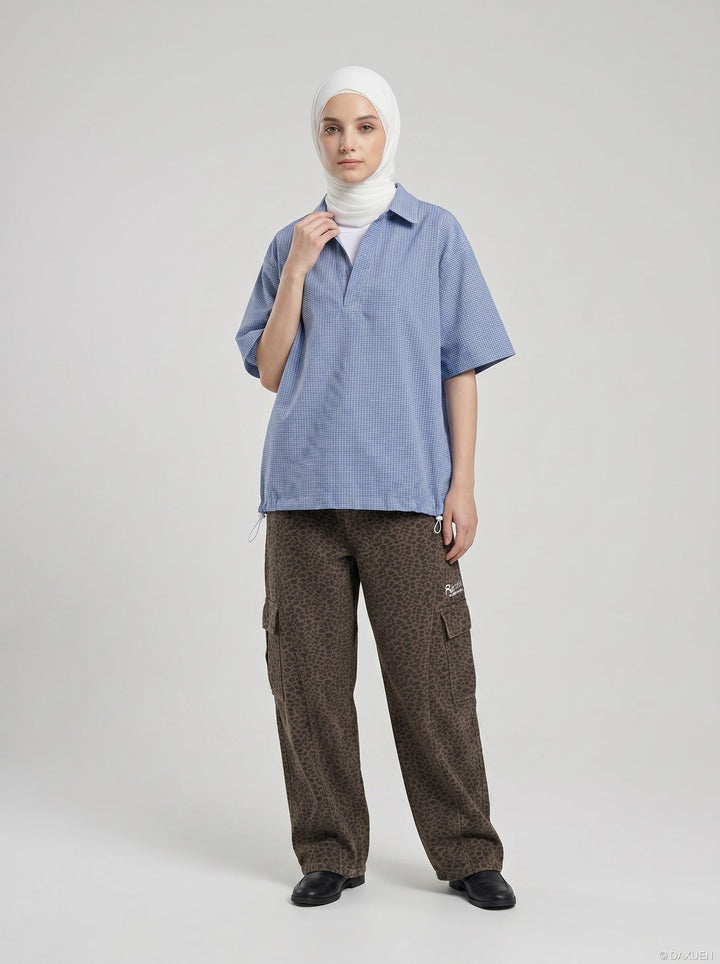 Model wearing men's blue and white gingham shirt side pose