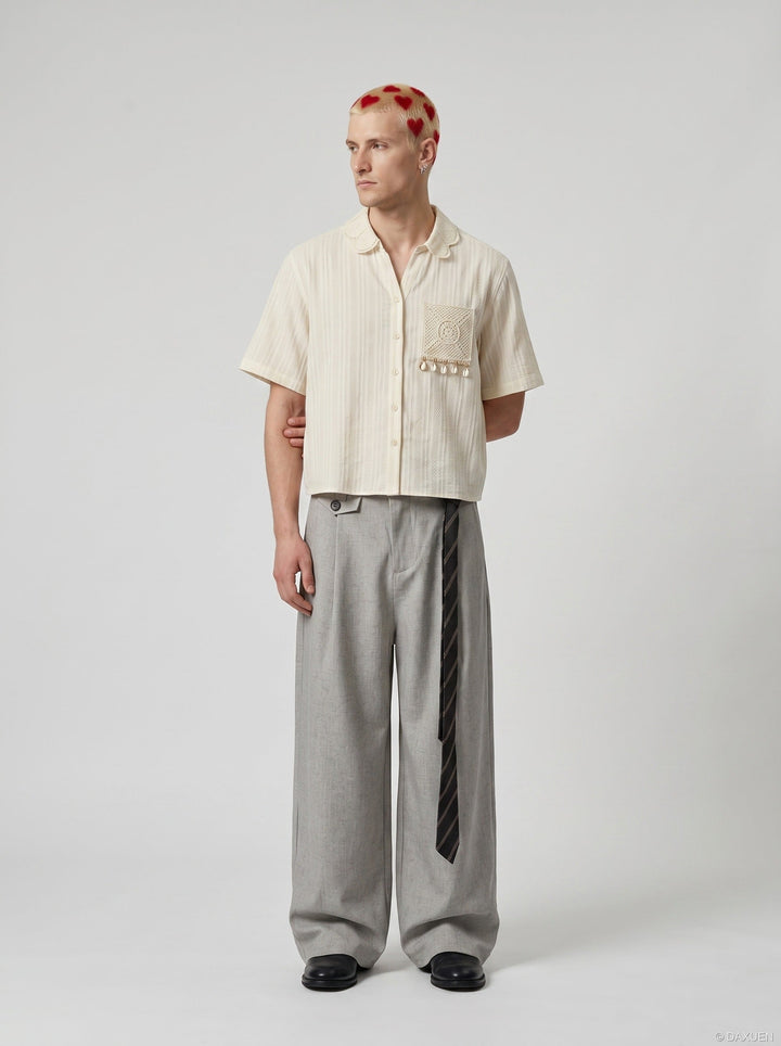 Close-up of embroidered detailing on the cream short sleeve shirt