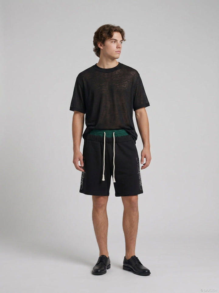 Sleeve and fabric detail of men's black sheer knit T-shirt