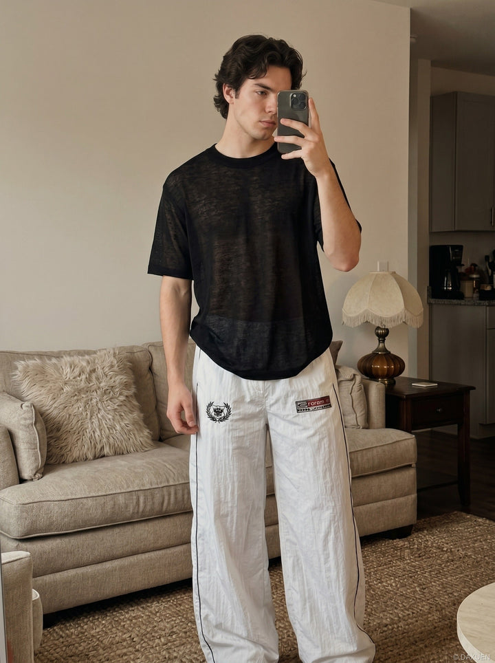 Angled front view of black sheer knit crew neck T-shirt for men