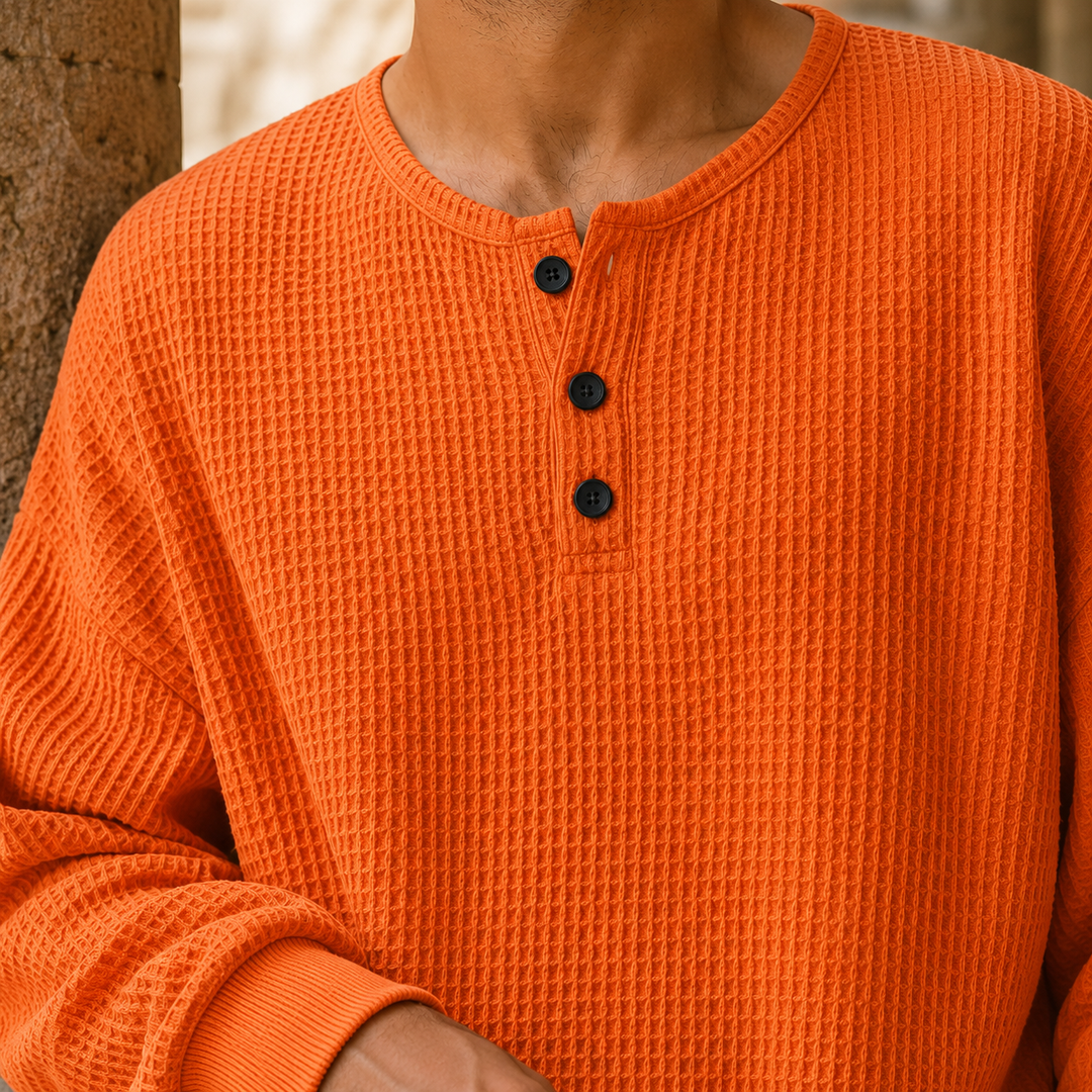 Men's waffle knit Henley sweater displaying its buttoned Henley neckline