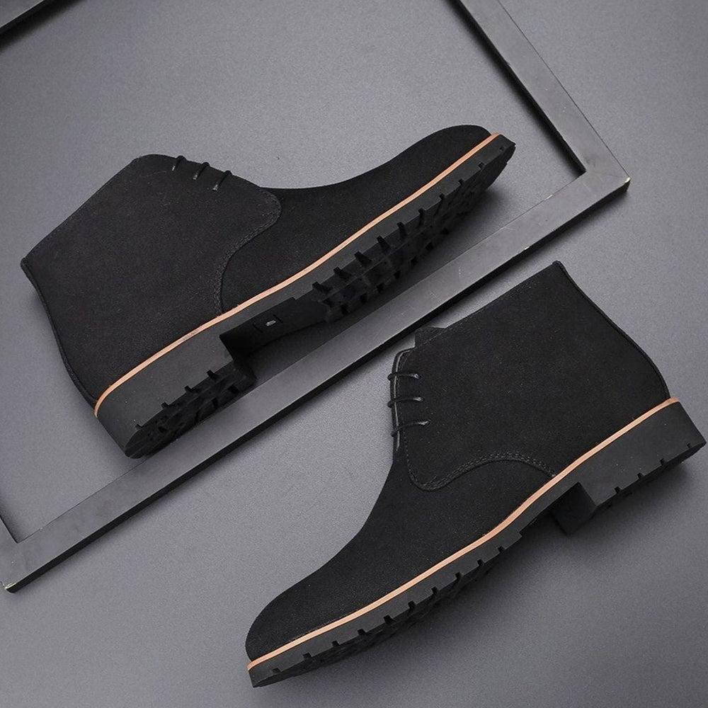 Men's suede chukka ankle boots with lace-up fronts on a plain background