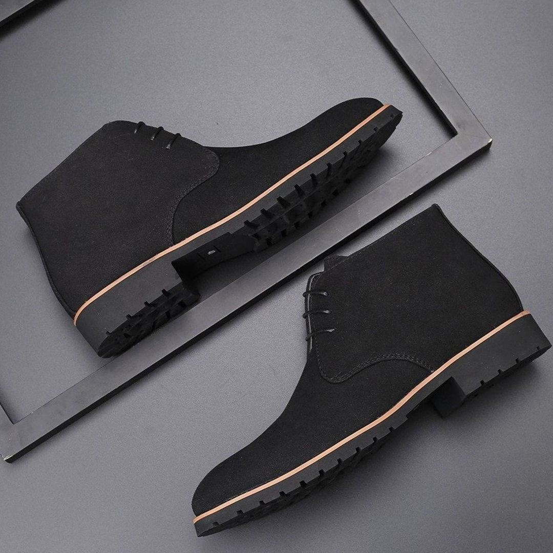 Men's suede chukka ankle boots with lace-up fronts on a plain background