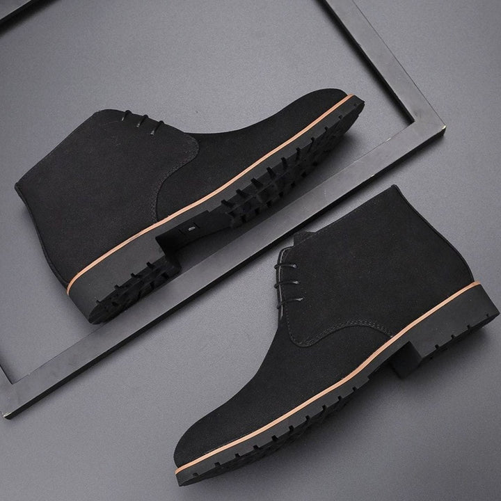 Men's suede chukka ankle boots with lace-up fronts on a plain background