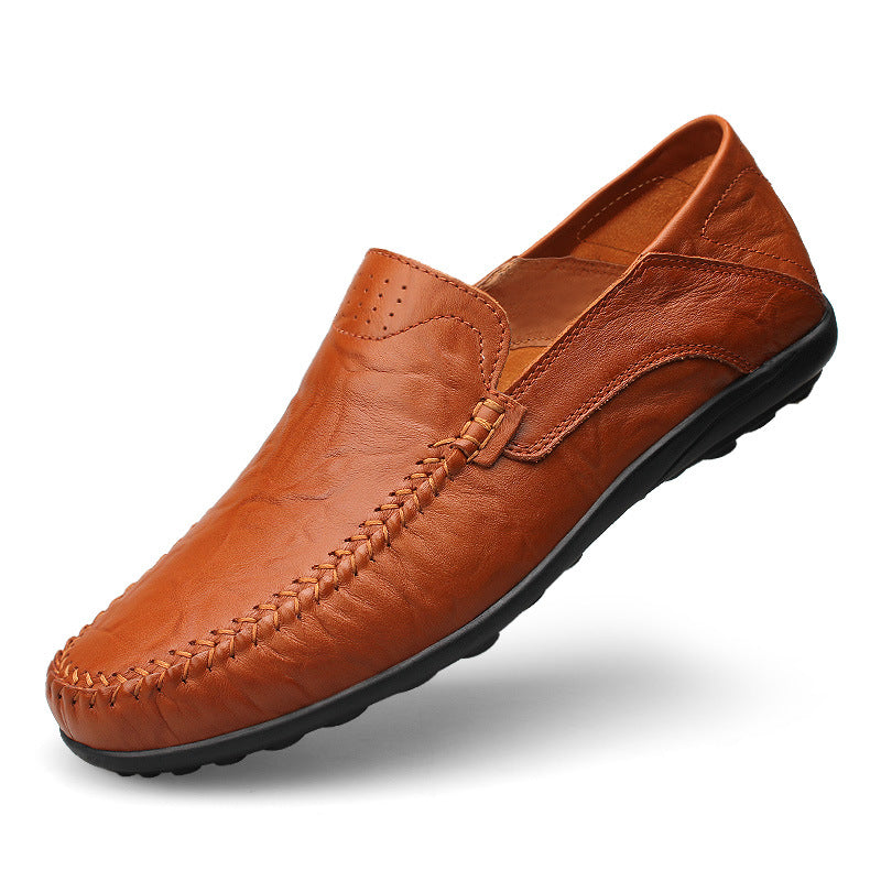Pair of men's moc toe slip-on loafers with perforated upper on a plain background
